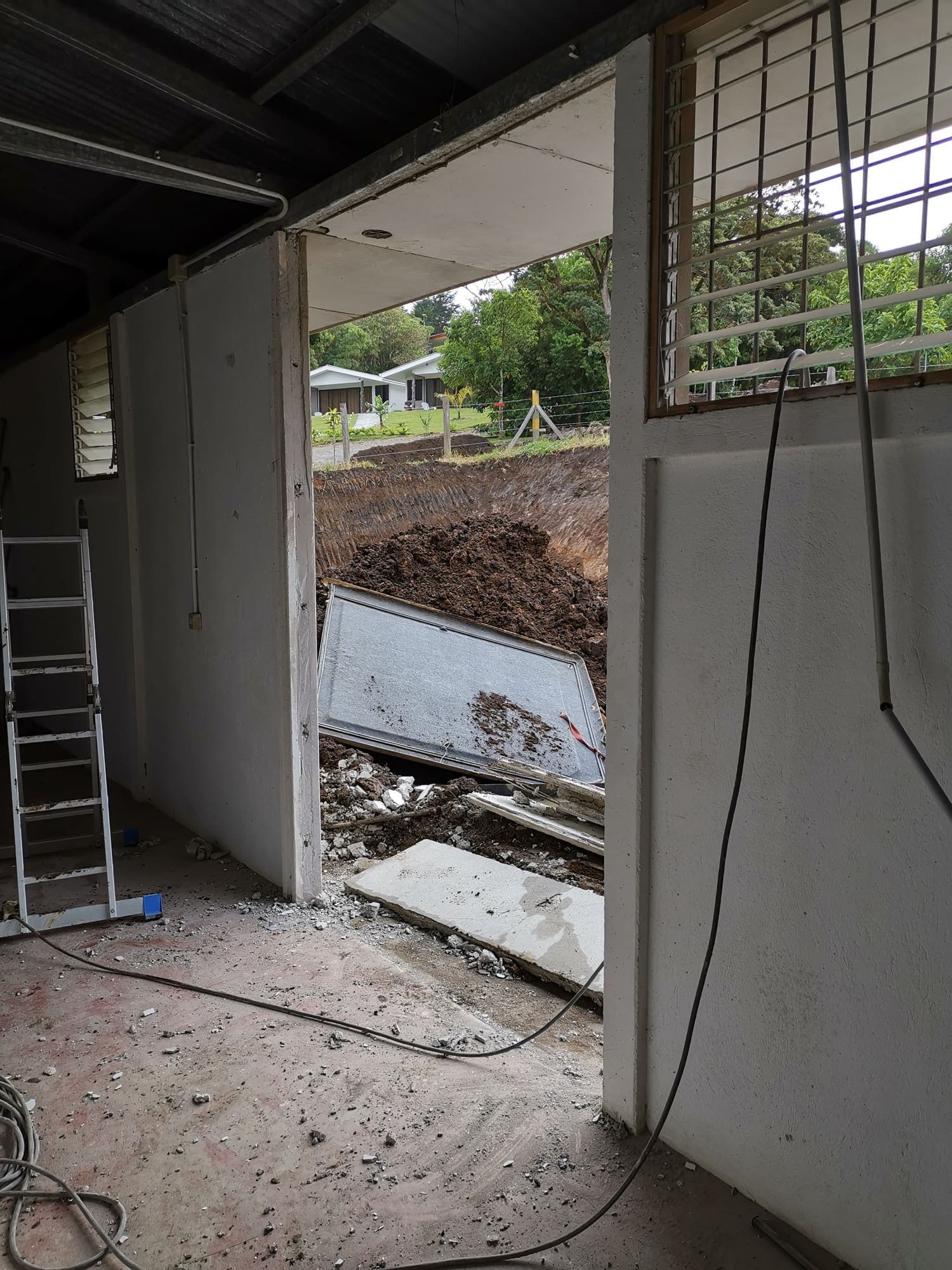 A doorway opened to the outside, a ladder leaning against it