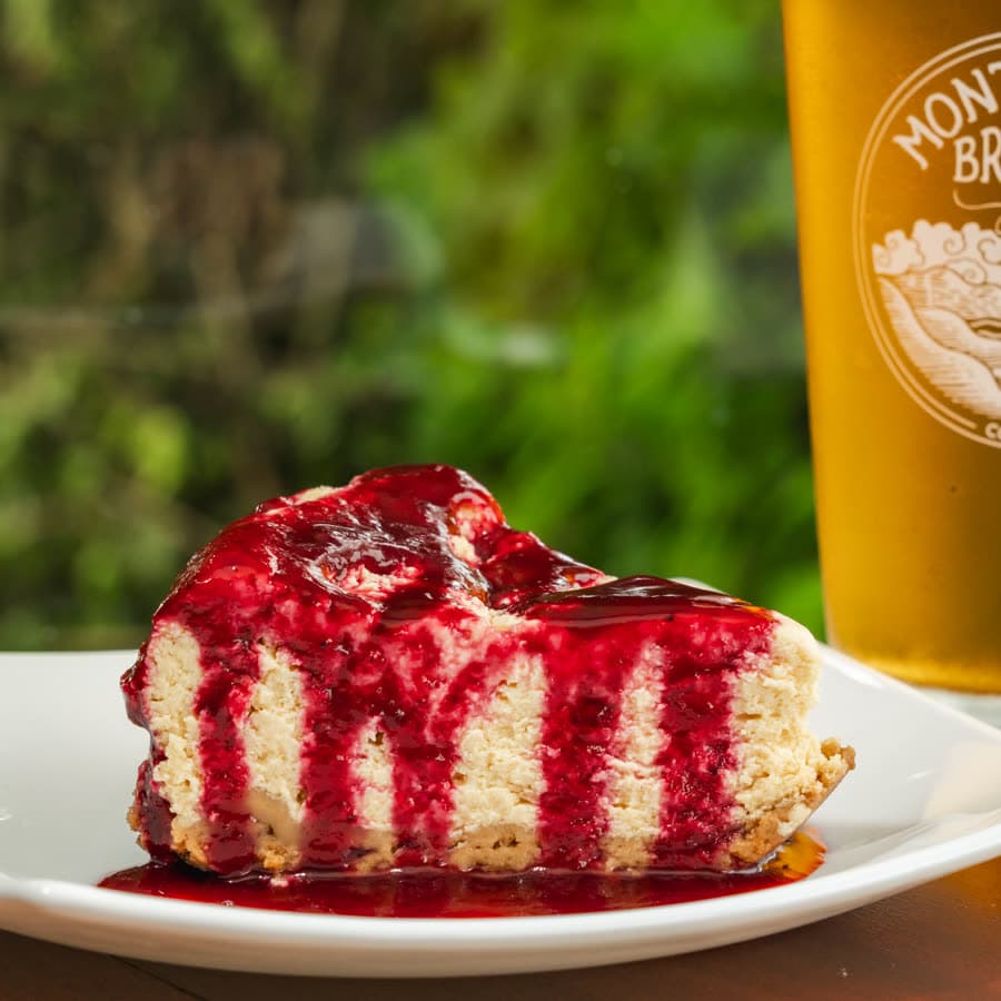 A slice of cheesecake with red berry sauce