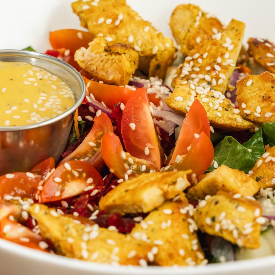 Chicken salad with tomato, sesame seeds and plantain chips