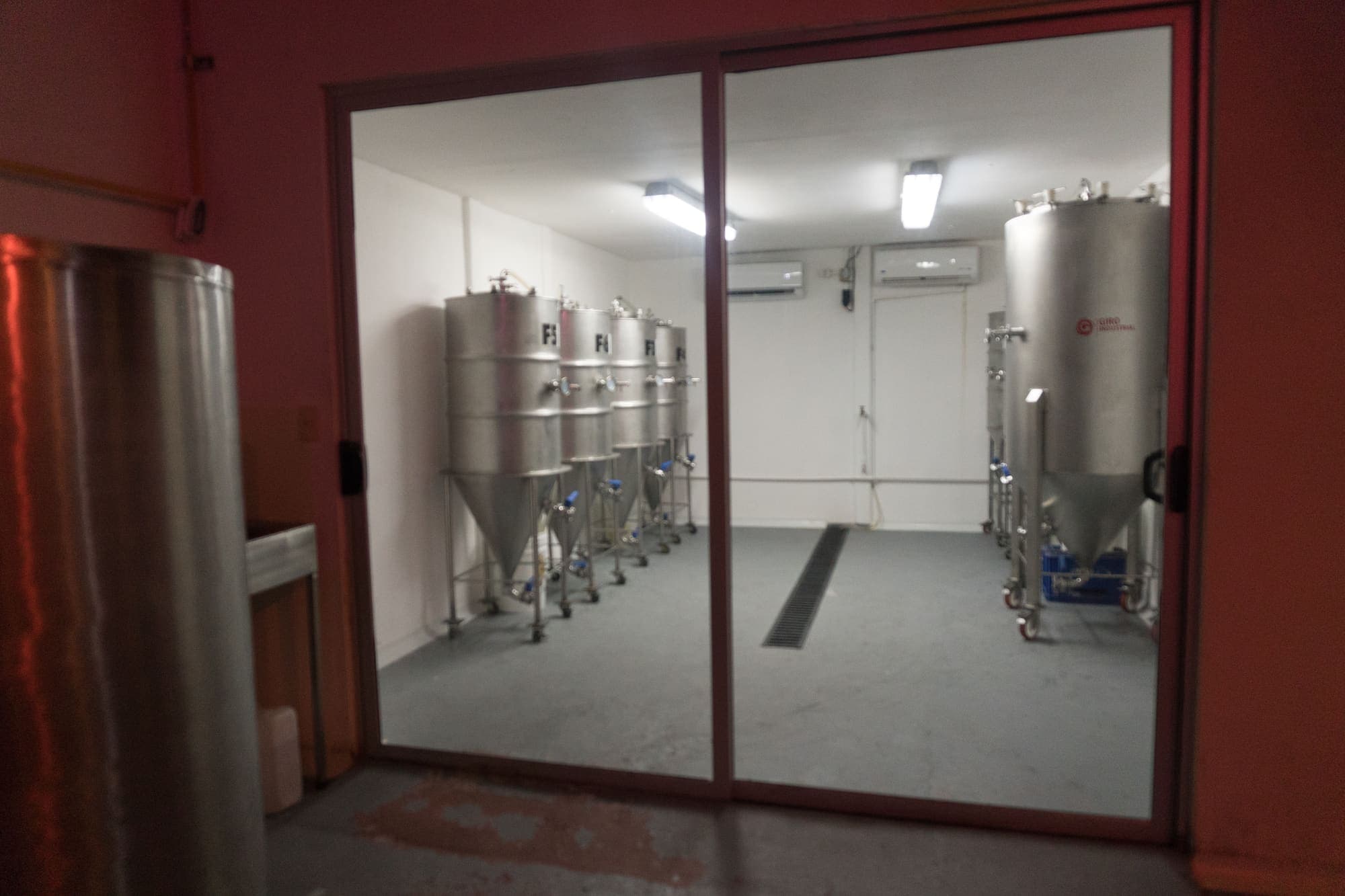 The Monteverde Brewing Company fermentation room behind glass, with its conical tanks