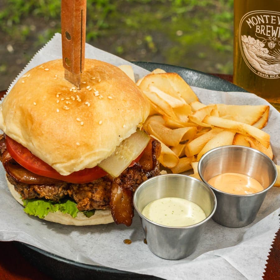 Breaded chicken burger with bacon, tomato and pickle