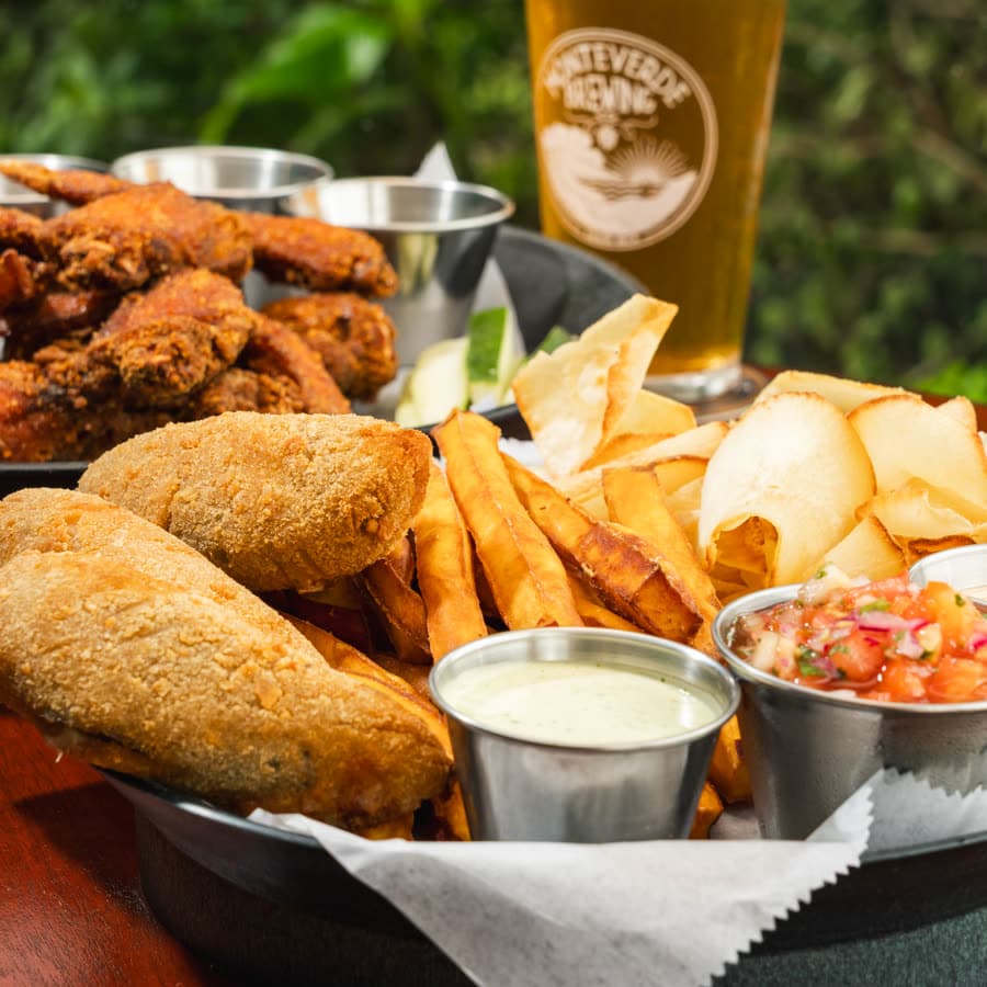 A sharing platter of wings, breaded bites, chips and dips
