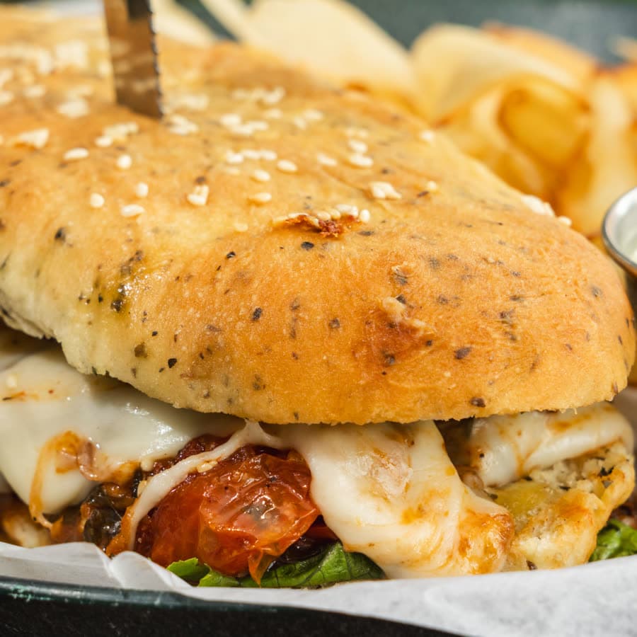 Pesto chicken sandwich with tomato and melted cheese